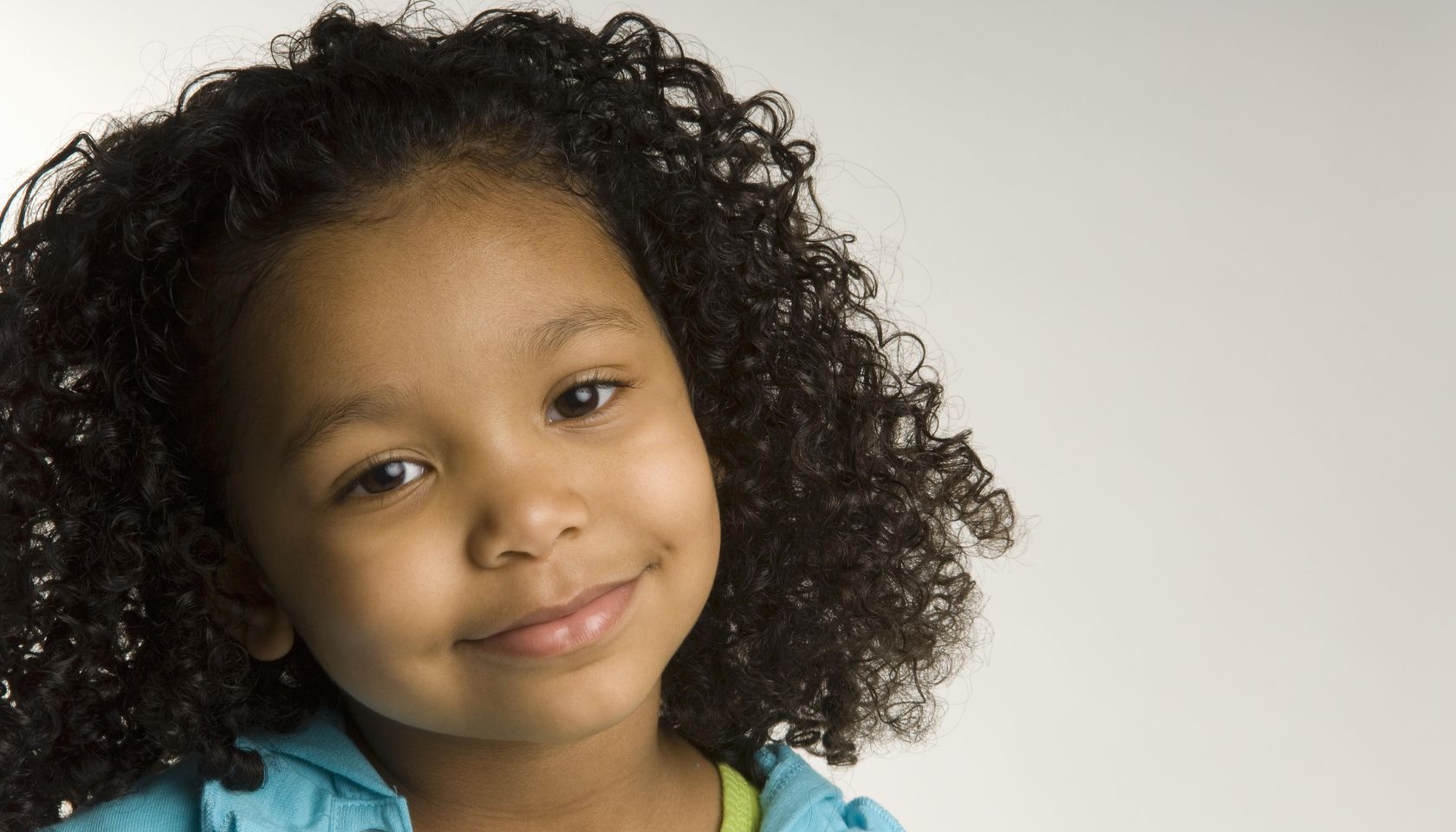 Portrait of young girl (4-5) smiling, studio shot
