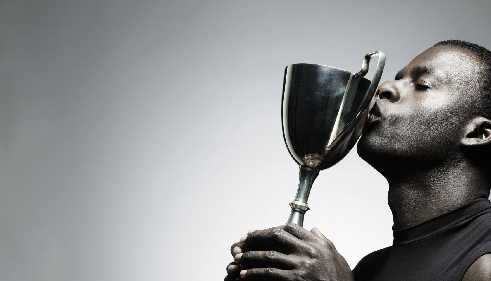 Young man kissing trophy, close-up