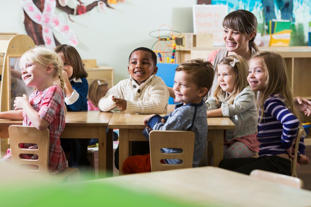 Teacher with group of preschoolers sitting at table