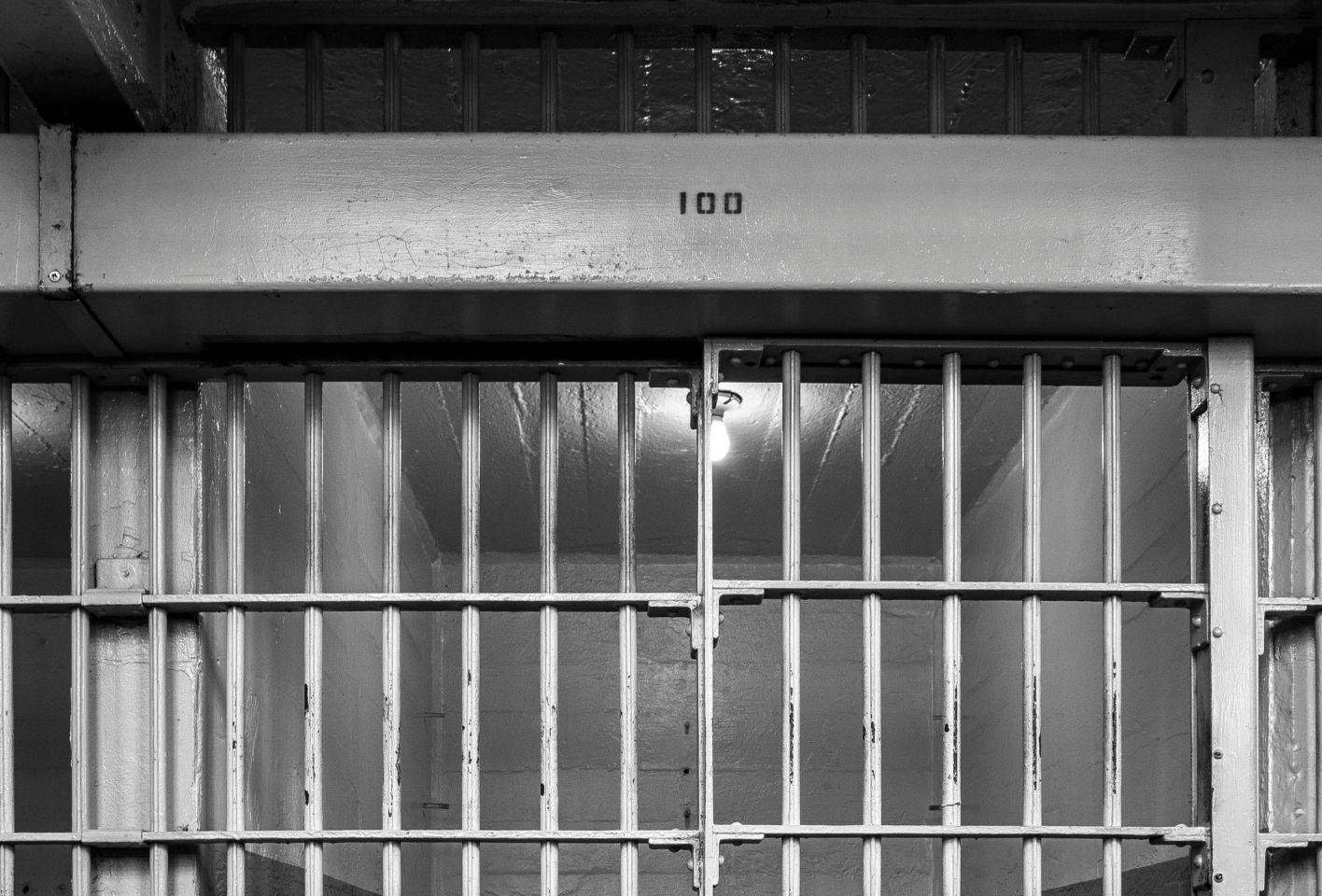 Empty Bed In Illuminated Prison Cell