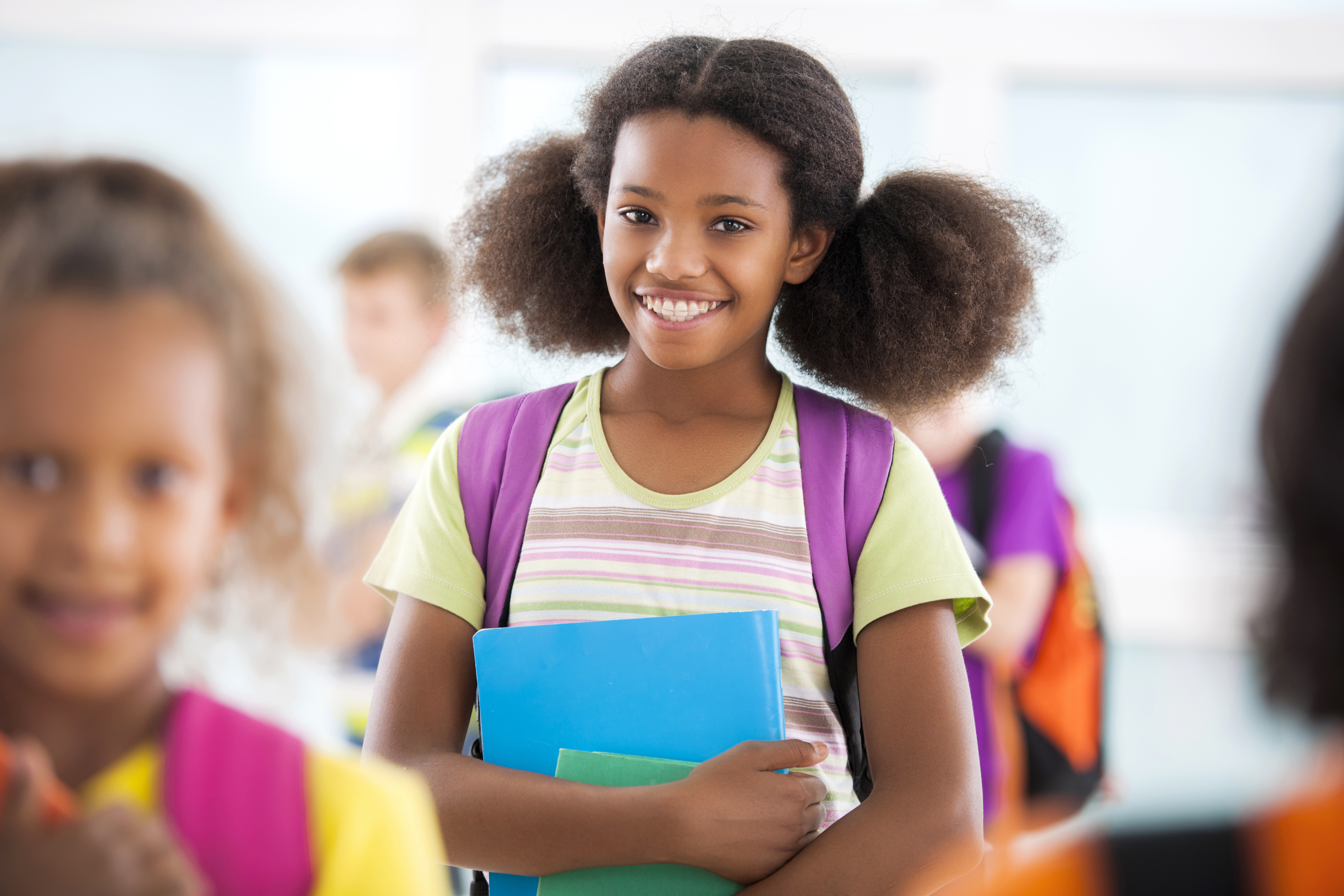 African American schoolgirl smiling and looking at camera.