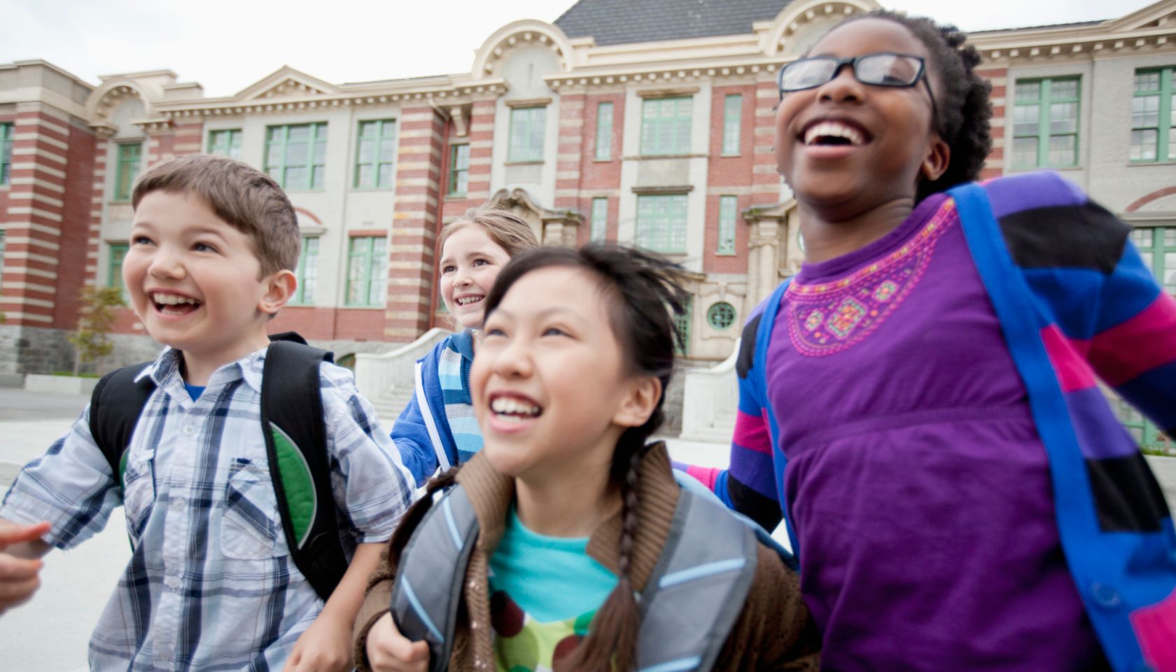 elementary students running outside school