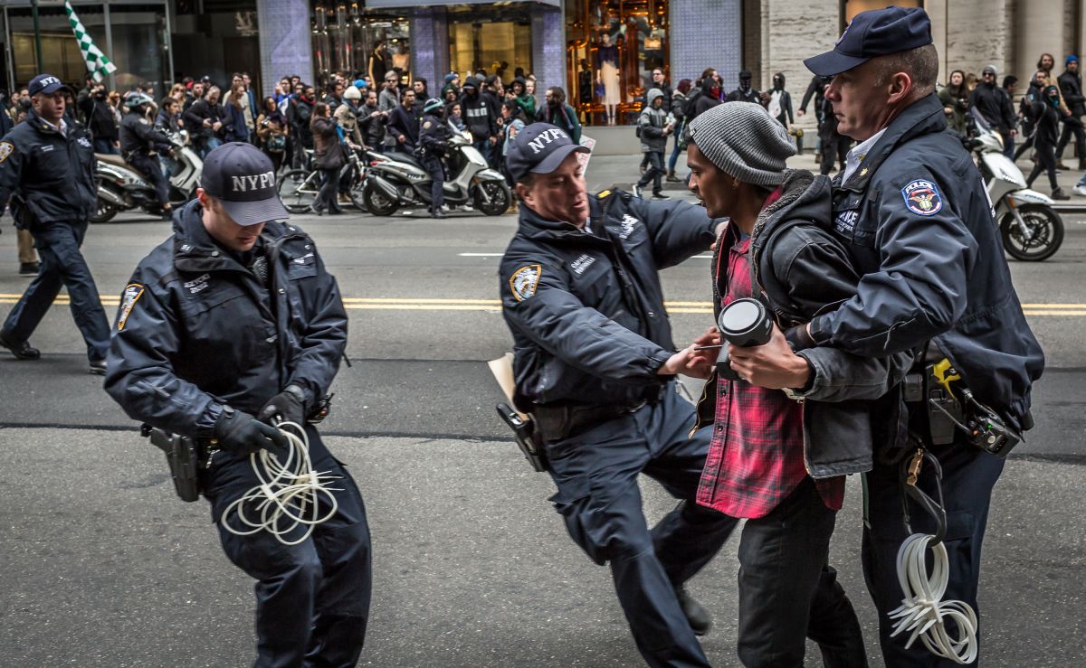 Policemen arrest a protester at the Anti-Trump rally.