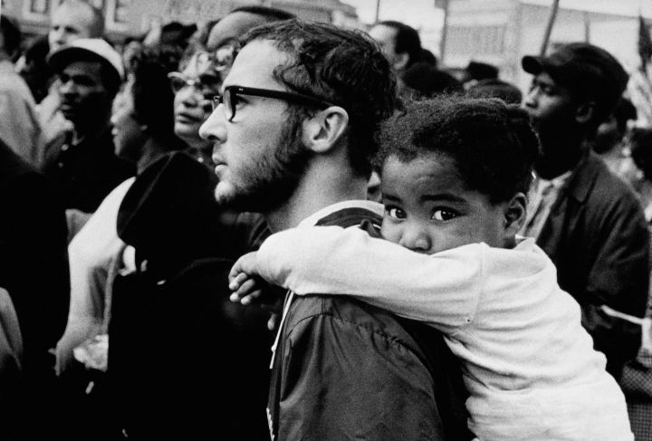 White Man Carrying Black Girl at March