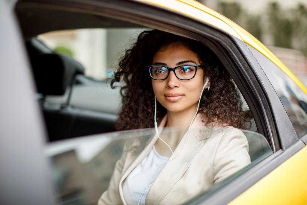 Businesswoman listening to music while commuting to work by taxi