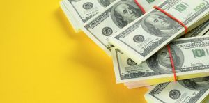 US dollars American Bills in Bundles On a Bright Yellow background.