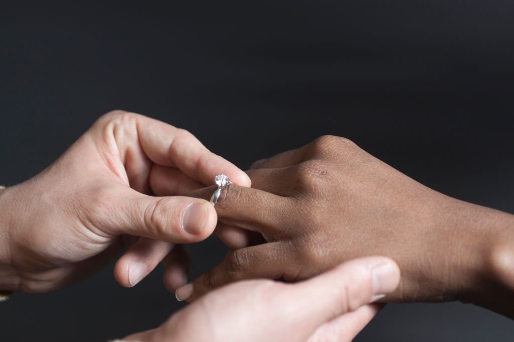 Man putting a wedding ring on a woman's finger