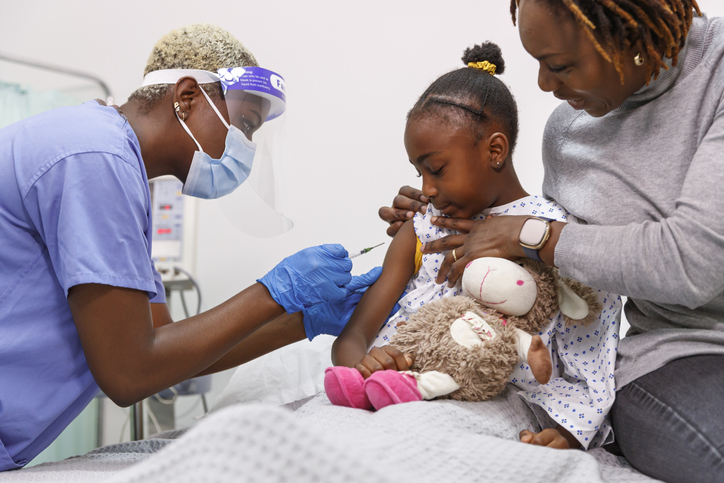 Nurse giving hospitalized sick child a vaccination