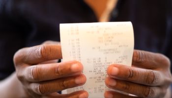 economy: black woman holding retail receipt
