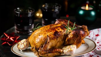 Roasted Turkey. Christmas table served with chicken, decorated with christmas decor and candles. Roasted chicken, table setting. Christmas dinner. New Year dinner.