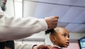 Black customers receive a haircut from barbers at a Black owned Barbershop