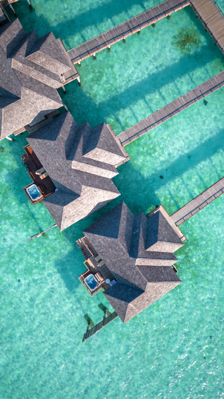 Maldives Island Overwater Villa Bungalows at turquoise hotel resort lagoon with aerial view