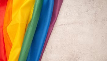 Top view of the rainbow flag or LGBT flag on a cement floor.