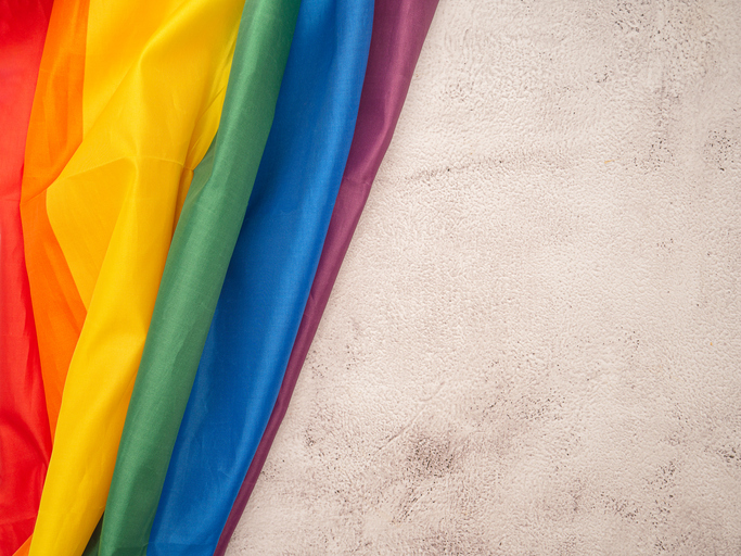 Top view of the rainbow flag or LGBT flag on a cement floor.