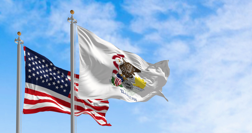 Illinois and US flags waving in the wind on a clear day