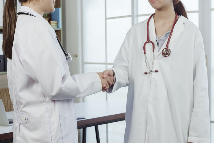 4k, Two Asian female doctors in white shirts are holding hands. Congratulations to each other for making the event a success through the cooperation of the two hospitals.