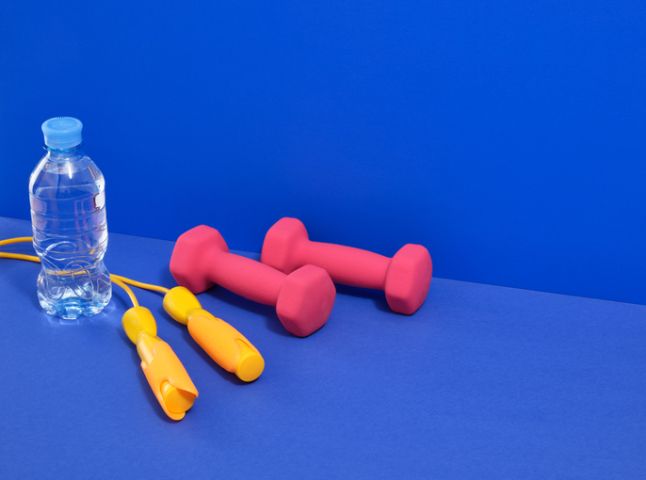 Dumbbells, sports rope and water for an effective workout, weight loss. Copy space for text.