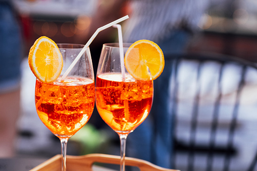 Close-up of wooden tray with two glasses of aperol