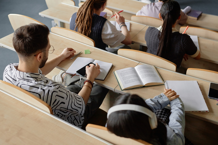 Students Attending Lecture Sitting at Desk at University
