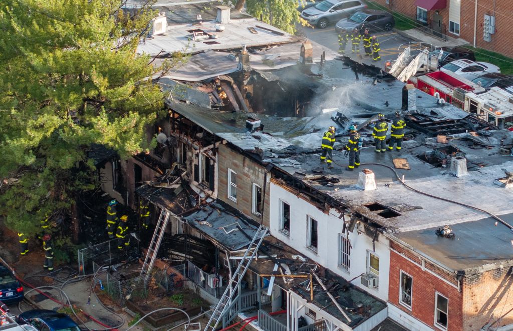 Baltimore City firefighters mop up a five-alarm blaze that affected multiple rowhomes in North Baltimore.