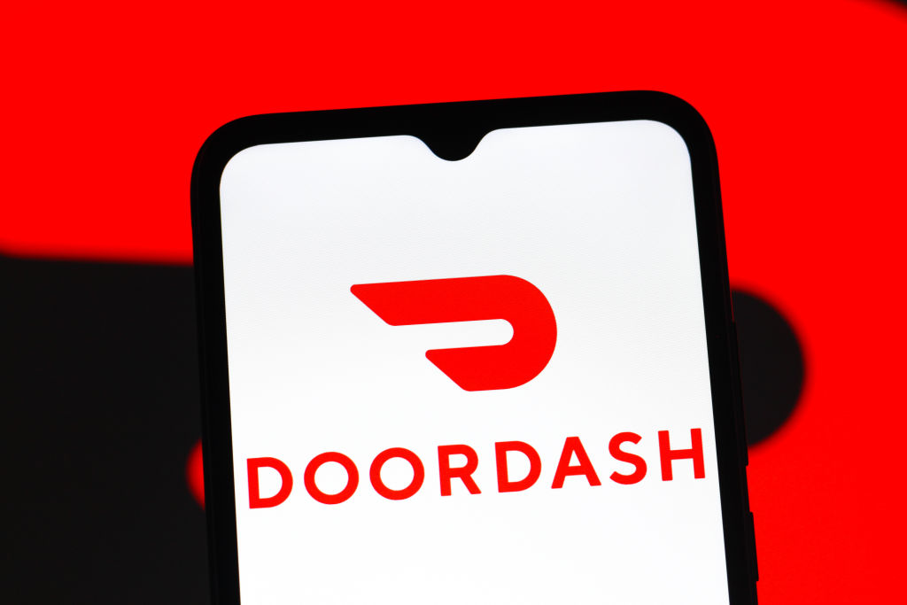 In this photo illustration, the DoorDash logo is seen...