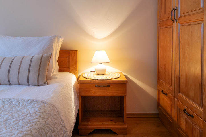 Bedroom lamp on night stand near sleeping bed
