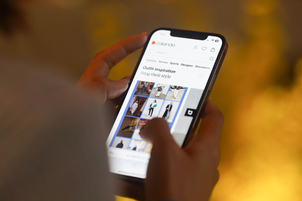 In this photo illustration, A woman browses Zalando on her...