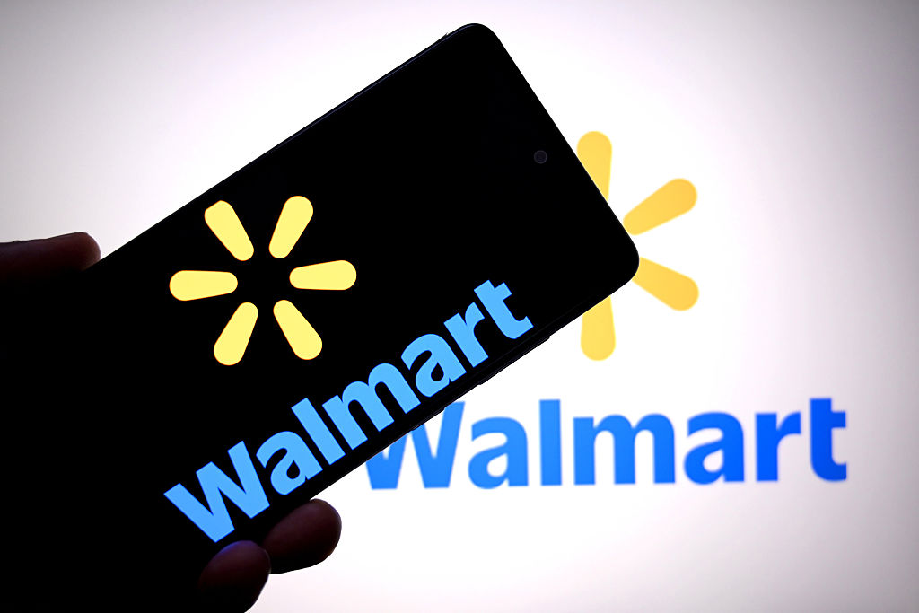 In this photo illustration, a Walmart logo is seen displayed...