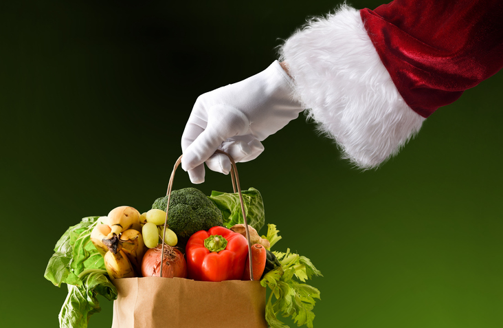 Santa's hand holding a bag full of food isolated background