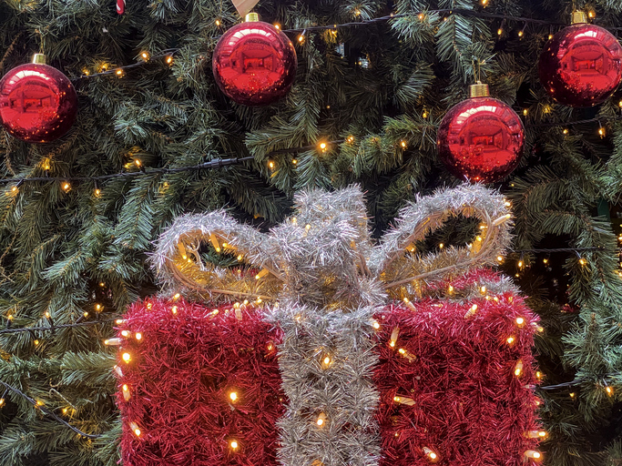 Large gift box decoration next to Christmas tree