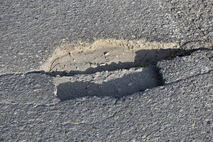 A damaged asphalt road with cracks