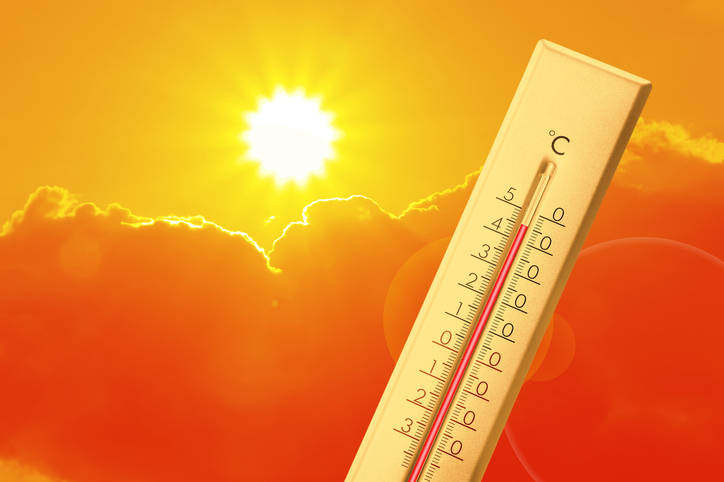 Extremely high temperature on thermometer against orange sky on sunny day. Severely hot summer weather