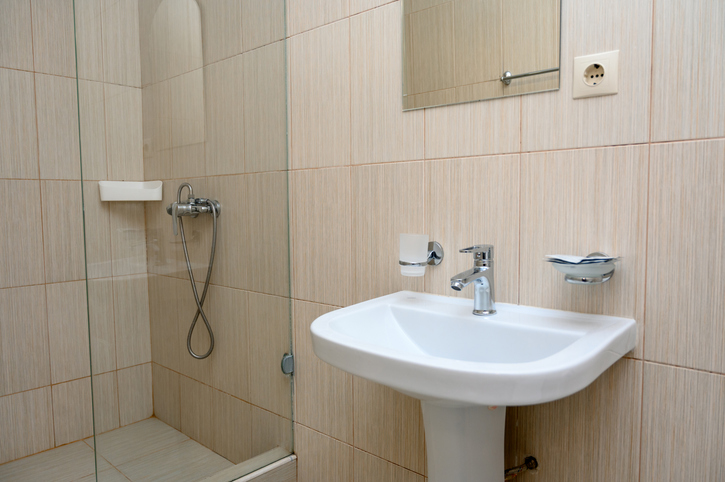 Modern bathroom interior with shower, sink, and tiled walls
