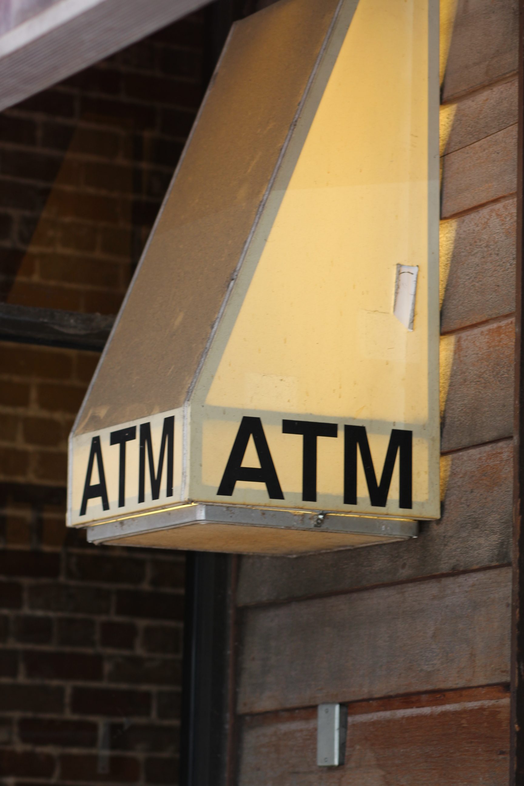 Exterior ATM sign on brick wall