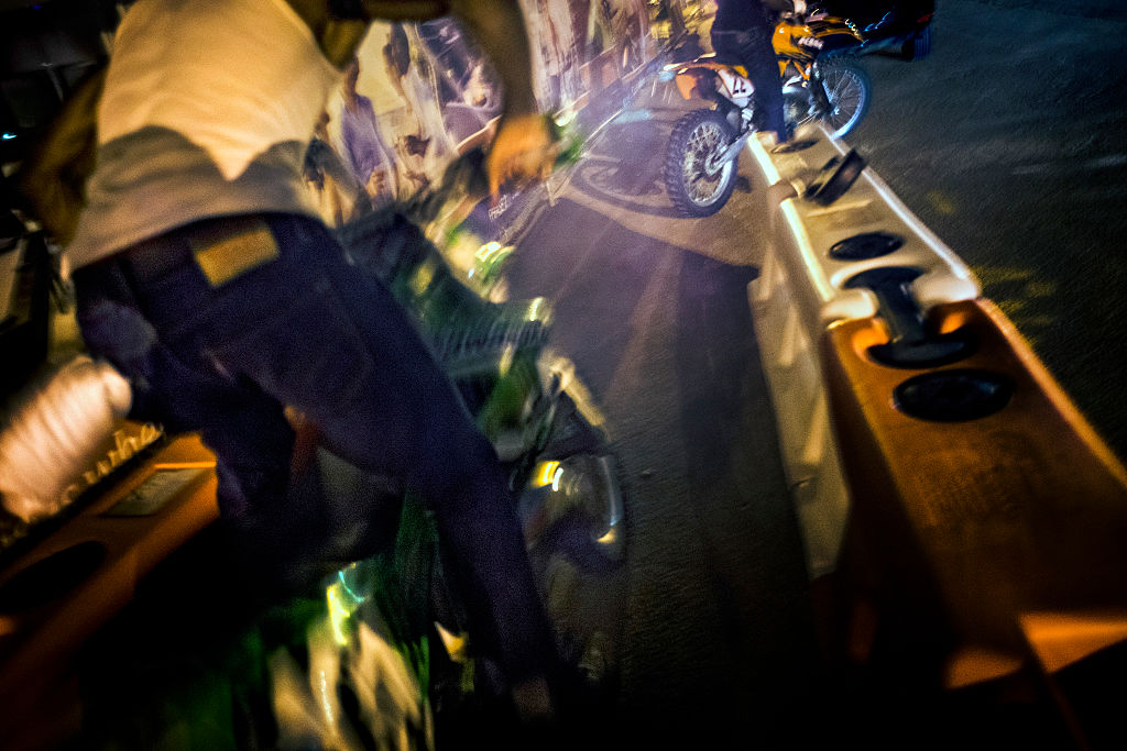 "Green Man", left, kick-starts his dirt bike behind the offices of NPR on Pierce Street in Washington