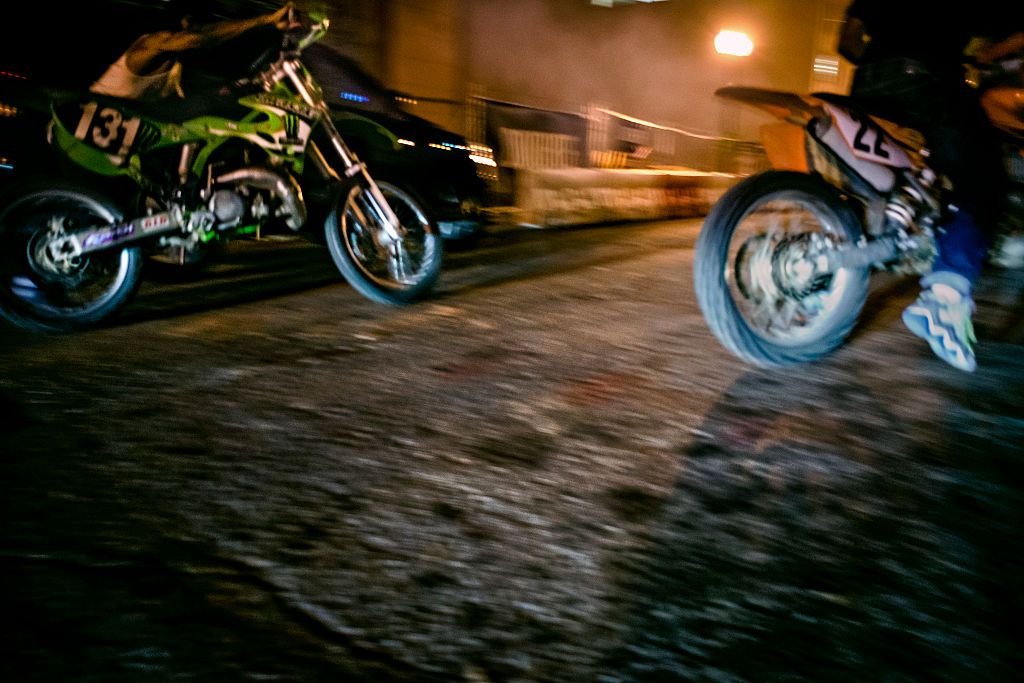 "Green Man", left, and another dirt biker race down Pierce Street behind the offices of NPR in Washington