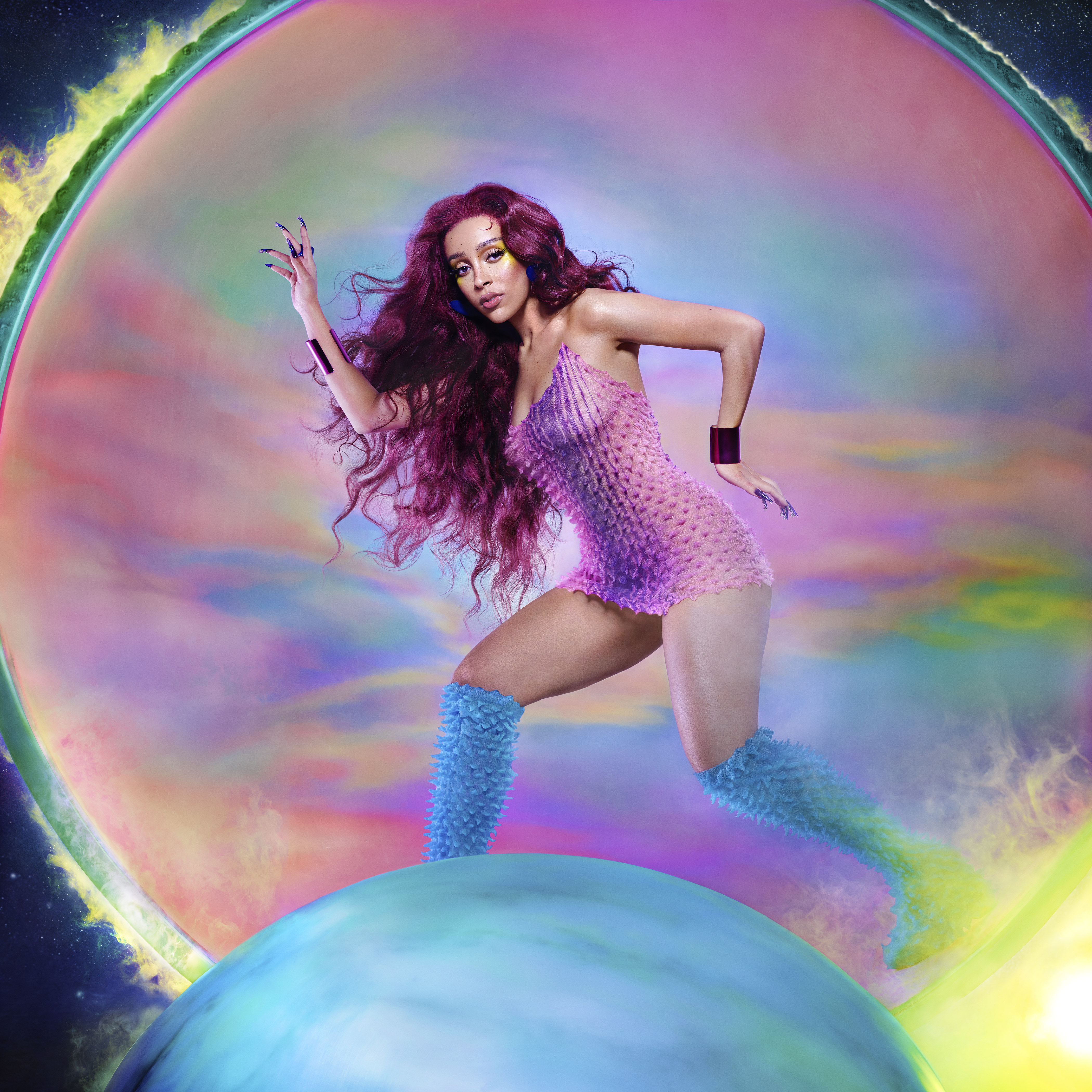 A person with long, wavy purple hair wearing a pink polka dot bodysuit and blue furry boots, posing in a colorful, psychedelic background.