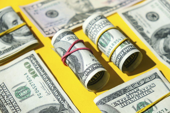US dollars bundle close up isolated on dollar background. Paper denominations of dollars cash rolls with rubber bands. Business budget of wealth and prosperity finance. Pile capital of American US dollars bills notes cash