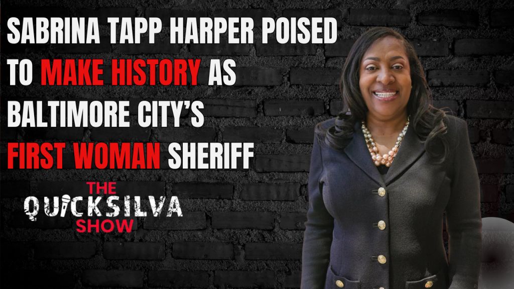 A smiling woman in a black suit standing in front of a brick wall, with text stating she is the first woman sheriff of Baltimore City.