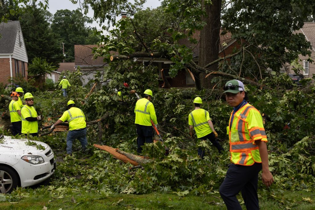 GAITHERSBURG, MD - JUNE 6: Workers use saws to clear out a fall