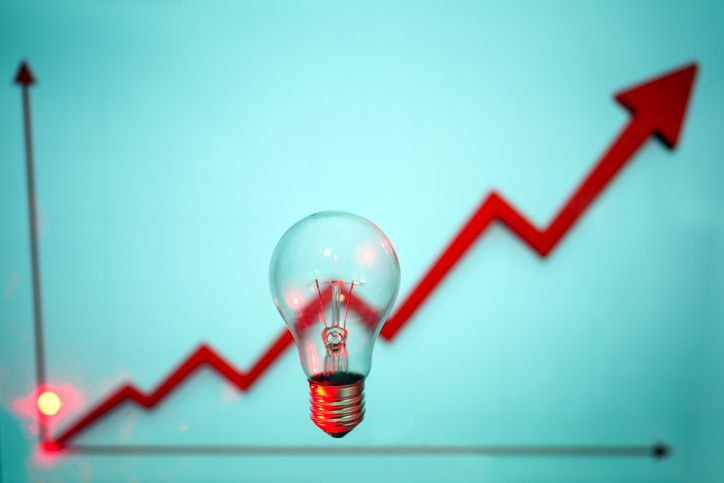 Light bulb with rising red arrow for energy crisis