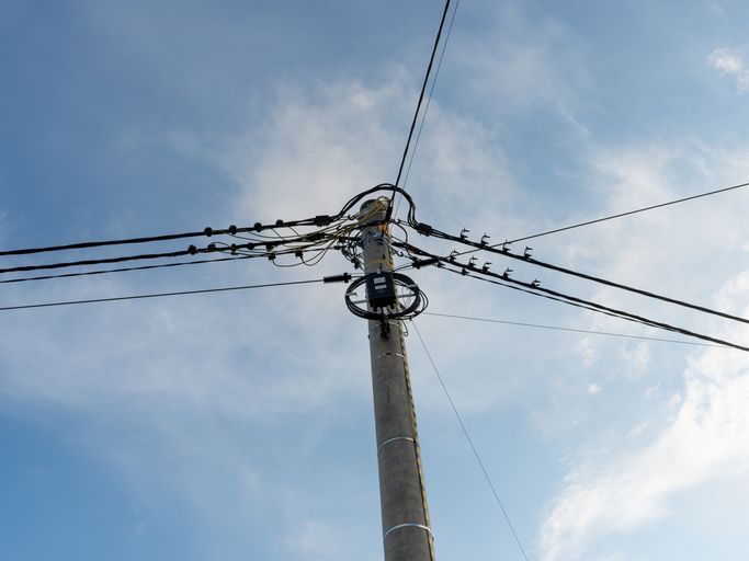 Concrete utility pole with dense overhead power and telecommunication cable network